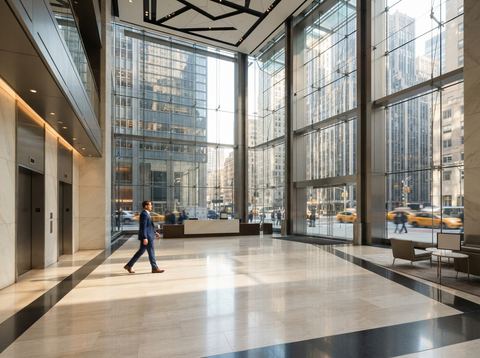 A bright glass skyscraper lobby in New York City representing a major financial services firm.