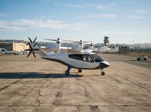 An electric vertical take-off aircraft prototype parked on a sunlit airfield tarmac.