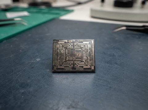 Macro photograph of a silicon NAND flash memory chip under bright studio lighting.